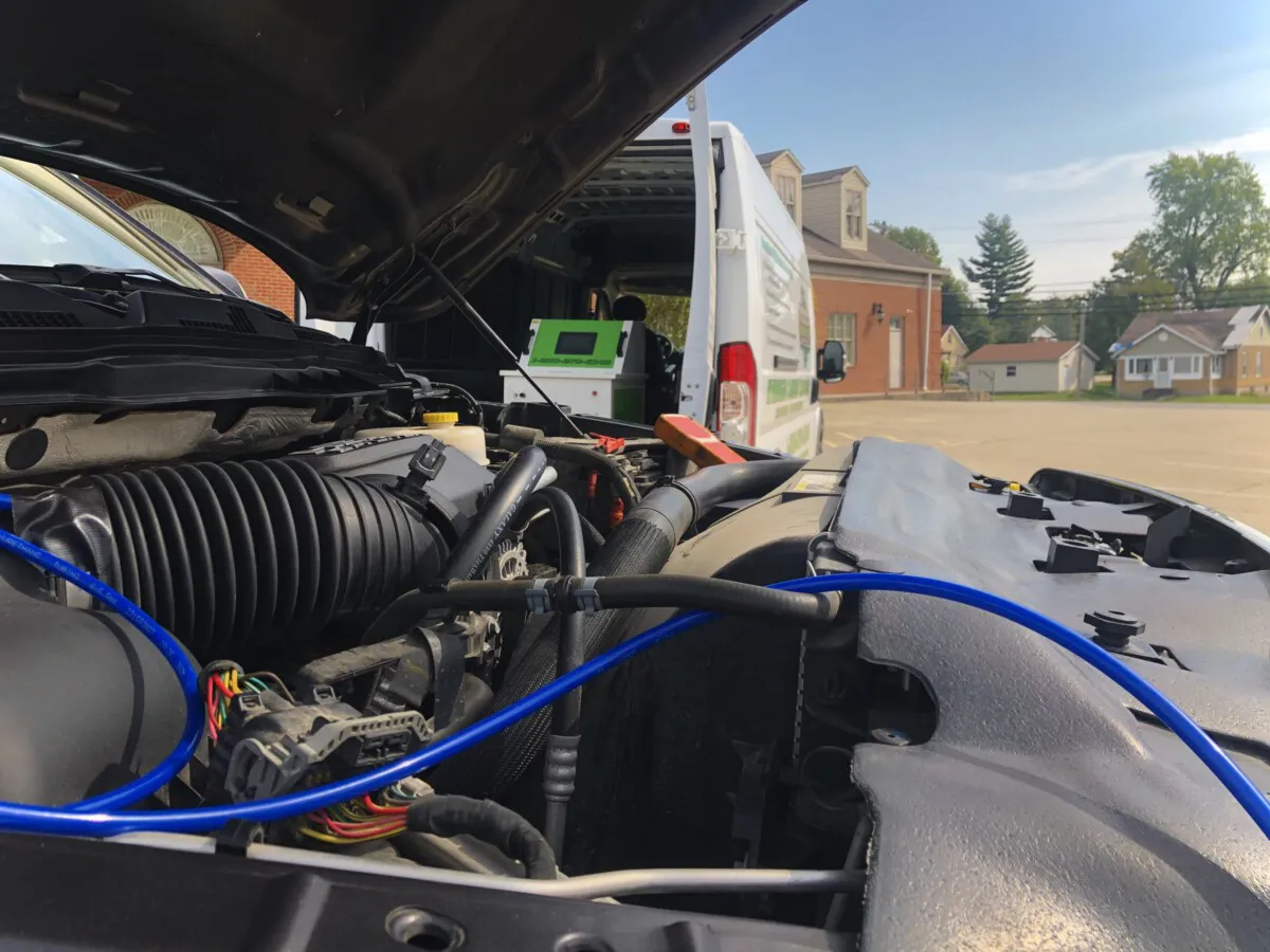 Car engine repair with van in background